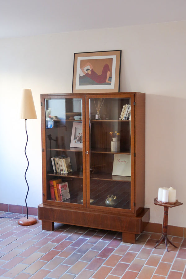 Bibliothèque vitrée vintage en bois de noyer, années 60, esprit Art déco, deux portes vitrées à encadrement de bois fermant à clé, quatre tablettes réglables, socle débordant à gradins sur deux patins pleins