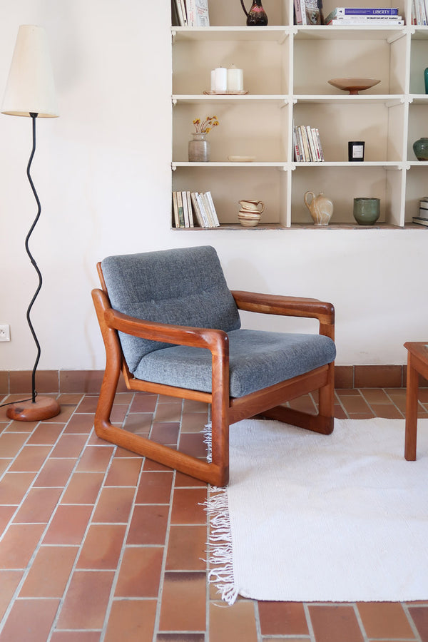 Fauteuil scandinave en teck Komfor avec coussins bleu gris déhoussables et piètement luge, fabriqué au Danemark.