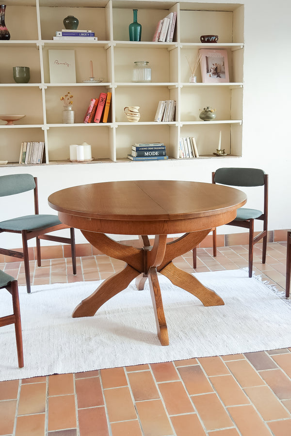 Table ronde vintage à rallonge en chêne massif éditée par Lübke, Allemagne années 60, estampille d'origine sous le plateau, piétement central à quatre jambes plates croisées en X réunies par un moyeu rond, allonge centrale