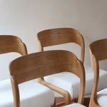 Lot de 4 chaises Baumann modèle Bémol en bois clair finition mate avec assises épaisses retapissées en bouclette écru.