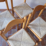 Chaises vintage en pin massif, lot de 4, assises paillées à la main tressées en épi, dossier à bandeau chantourné en arc, montants tournés à boule et pieds ronds réunis par des barreaux