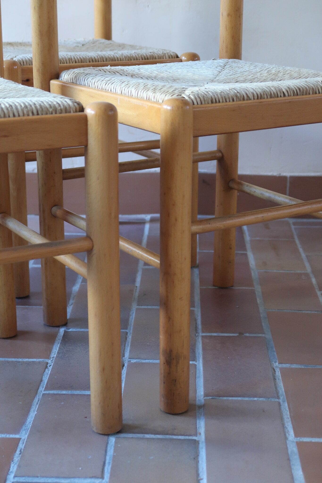 Chaises vintage en pin massif, lot de 4, assises paillées à la main tressées en épi, dossier à bandeau chantourné en arc, montants tournés à boule et pieds ronds réunis par des barreaux