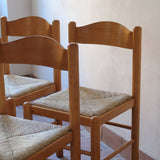 Chaises vintage en pin massif, lot de 4, assises paillées à la main tressées en épi, dossier à bandeau chantourné en arc, montants tournés à boule et pieds ronds réunis par des barreaux