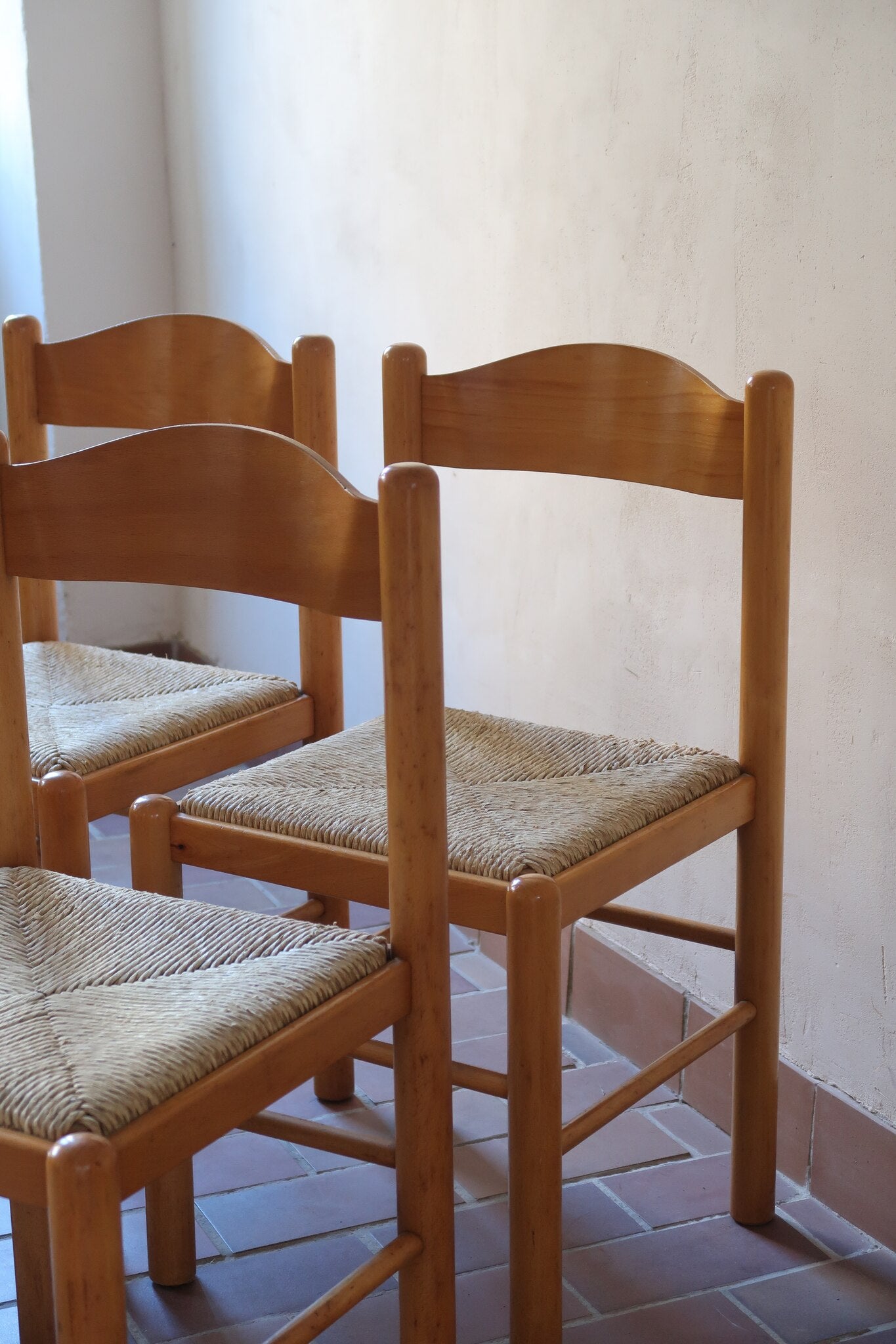 Chaises vintage en pin massif, lot de 4, assises paillées à la main tressées en épi, dossier à bandeau chantourné en arc, montants tournés à boule et pieds ronds réunis par des barreaux