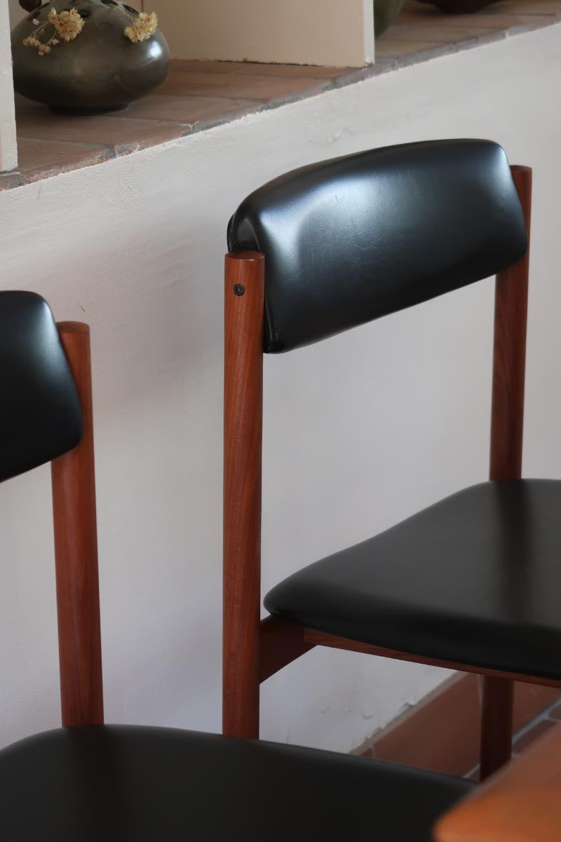 4 chaises danoises vintage en teck et skaï noir. Style scandinave années 60, chic et intemporel.