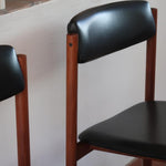 4 chaises danoises vintage en teck et skaï noir. Style scandinave années 60, chic et intemporel.