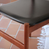 4 chaises danoises vintage en teck et skaï noir. Style scandinave années 60, chic et intemporel.