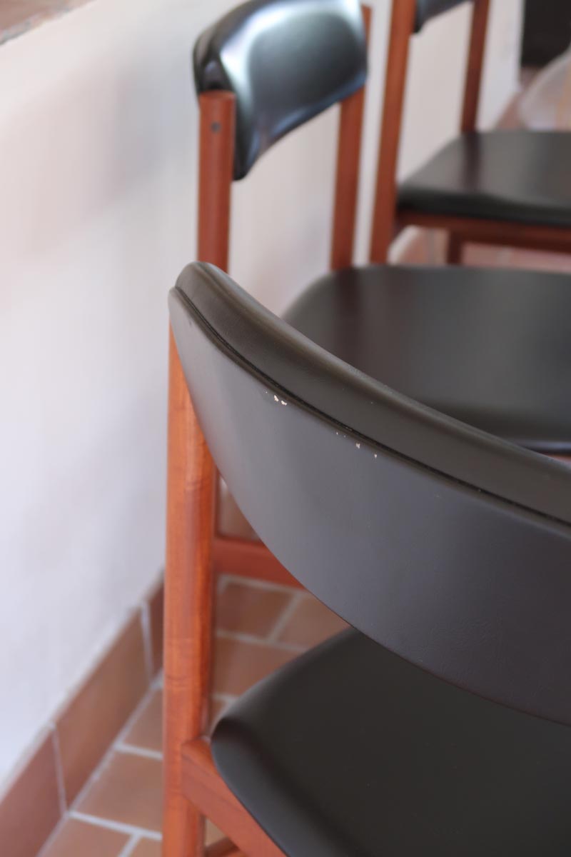 4 chaises danoises vintage en teck et skaï noir. Style scandinave années 60, chic et intemporel.
