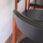 4 chaises danoises vintage en teck et skaï noir. Style scandinave années 60, chic et intemporel.