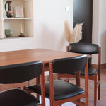 4 chaises danoises vintage en teck et skaï noir. Style scandinave années 60, chic et intemporel.