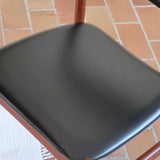 4 chaises danoises vintage en teck et skaï noir. Style scandinave années 60, chic et intemporel.