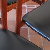 4 chaises danoises vintage en teck et skaï noir. Style scandinave années 60, chic et intemporel.