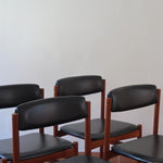 4 chaises danoises vintage en teck et skaï noir. Style scandinave années 60, chic et intemporel.