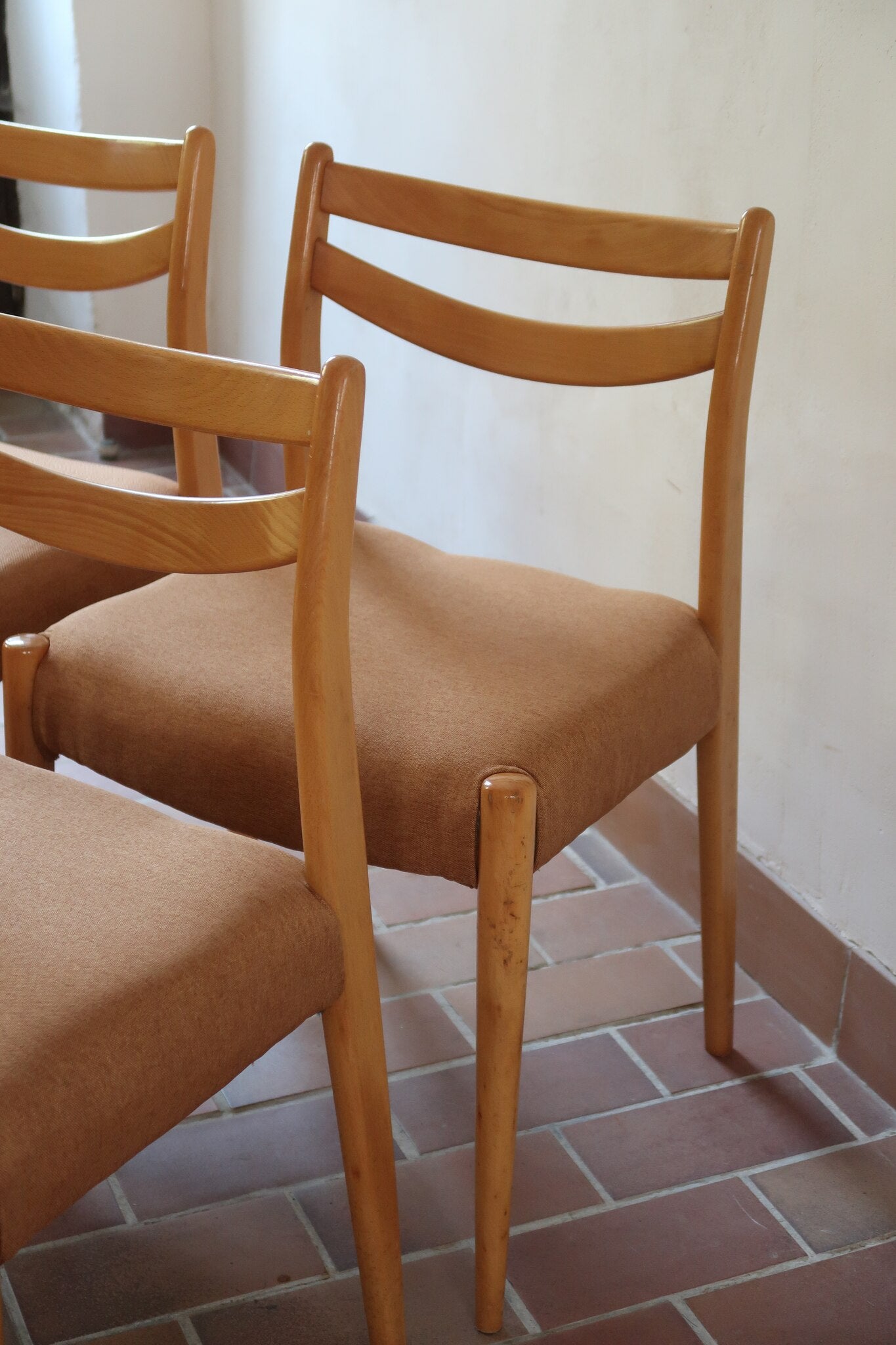 Chaises scandinaves vintage en bois clair, lot de 4, dossier à deux barreaux courbes, pieds arrière en sabre et pieds avant fuselés, assises retapissées en lainage brun moka