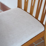 Lot de six chaises vintage scandinaves des années 60 en hêtre massif, dossier à barreaux galbés et assise en tissu clair, posées sur carrelage rouge.