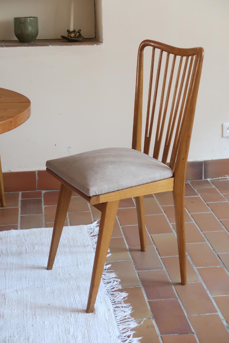 Lot de six chaises vintage scandinaves des années 60 en hêtre massif, dossier à barreaux galbés et assise en tissu clair, posées sur carrelage rouge.