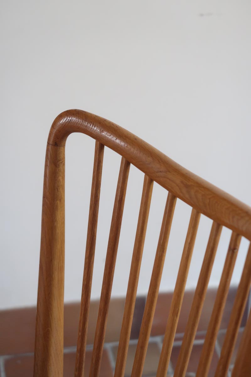 Lot de six chaises vintage scandinaves des années 60 en hêtre massif, dossier à barreaux galbés et assise en tissu clair, posées sur carrelage rouge.