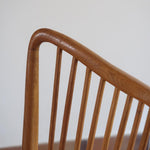 Lot de six chaises vintage scandinaves des années 60 en hêtre massif, dossier à barreaux galbés et assise en tissu clair, posées sur carrelage rouge.