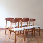 Six chaises scandinaves en hêtre et dossier teck, fabrication danoise des années 60, retapissées en bouclette écrue.