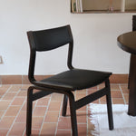 Suite de 6 chaises danoises vintage années 60, bois teinté brun, pieds arrière cintrés filant jusqu'au dossier bandeau, assises et dossiers retapissés en skaï noir