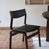 Suite de 6 chaises danoises vintage années 60, bois teinté brun, pieds arrière cintrés filant jusqu'au dossier bandeau, assises et dossiers retapissés en skaï noir