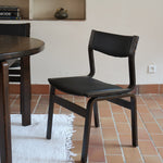 Suite de 6 chaises danoises vintage années 60, bois teinté brun, pieds arrière cintrés filant jusqu'au dossier bandeau, assises et dossiers retapissés en skaï noir