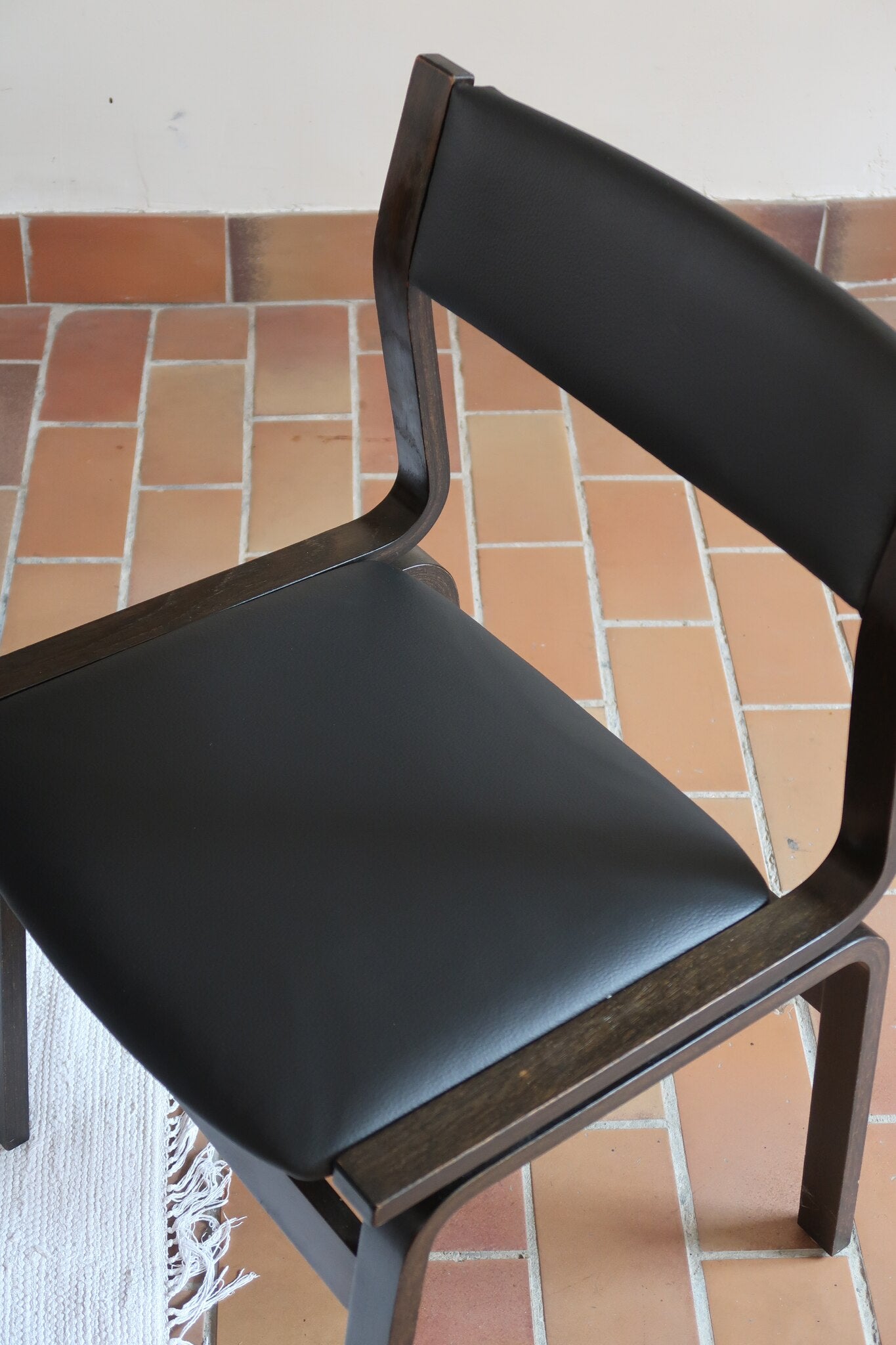 Suite de 6 chaises danoises vintage années 60, bois teinté brun, pieds arrière cintrés filant jusqu'au dossier bandeau, assises et dossiers retapissés en skaï noir