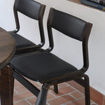 Suite de 6 chaises danoises vintage années 60, bois teinté brun, pieds arrière cintrés filant jusqu'au dossier bandeau, assises et dossiers retapissés en skaï noir