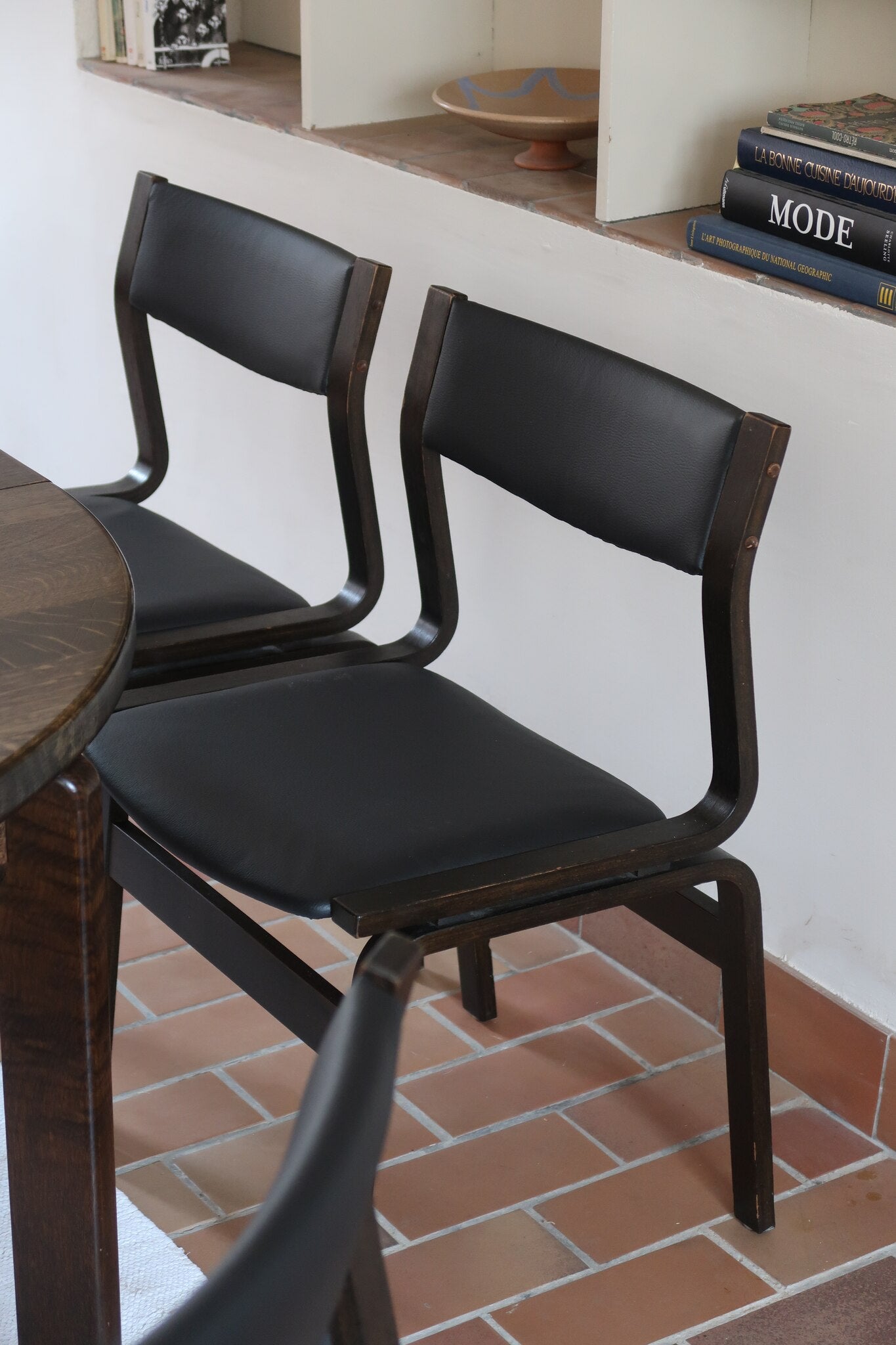 Suite de 6 chaises danoises vintage années 60, bois teinté brun, pieds arrière cintrés filant jusqu'au dossier bandeau, assises et dossiers retapissés en skaï noir