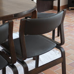 Suite de 6 chaises danoises vintage années 60, bois teinté brun, pieds arrière cintrés filant jusqu'au dossier bandeau, assises et dossiers retapissés en skaï noir