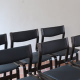 Suite de 6 chaises danoises vintage années 60, bois teinté brun, pieds arrière cintrés filant jusqu'au dossier bandeau, assises et dossiers retapissés en skaï noir