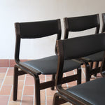 Suite de 6 chaises danoises vintage années 60, bois teinté brun, pieds arrière cintrés filant jusqu'au dossier bandeau, assises et dossiers retapissés en skaï noir