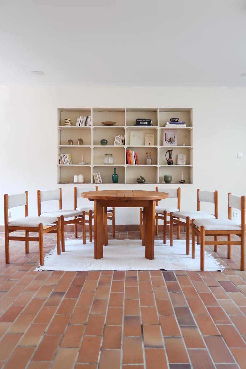 Lot de six chaises vintage des années 80 en pin massif avec assise et dossier en tissu bouclette blanc cassé, style Charlotte Perriand, présentées seules ou mises en situation dans différents espaces.