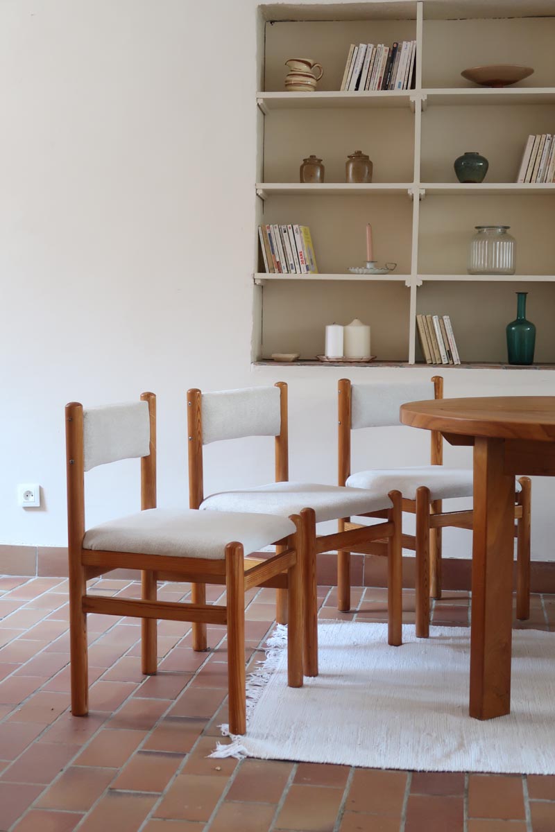 Lot de six chaises vintage des années 80 en pin massif avec assise et dossier en tissu bouclette blanc cassé, style Charlotte Perriand, présentées seules ou mises en situation dans différents espaces.