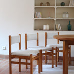 Lot de six chaises vintage des années 80 en pin massif avec assise et dossier en tissu bouclette blanc cassé, style Charlotte Perriand, présentées seules ou mises en situation dans différents espaces.
