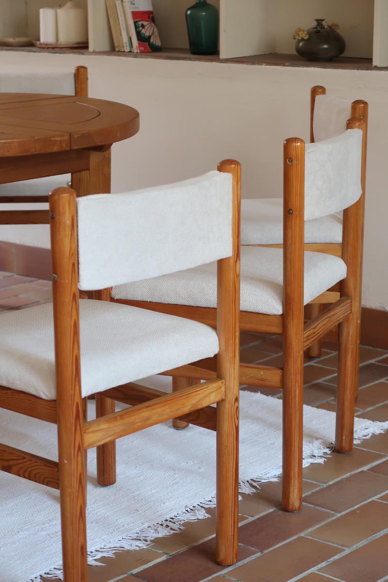 Lot de six chaises vintage des années 80 en pin massif avec assise et dossier en tissu bouclette blanc cassé, style Charlotte Perriand, présentées seules ou mises en situation dans différents espaces.