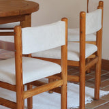 Lot de six chaises vintage des années 80 en pin massif avec assise et dossier en tissu bouclette blanc cassé, style Charlotte Perriand, présentées seules ou mises en situation dans différents espaces.