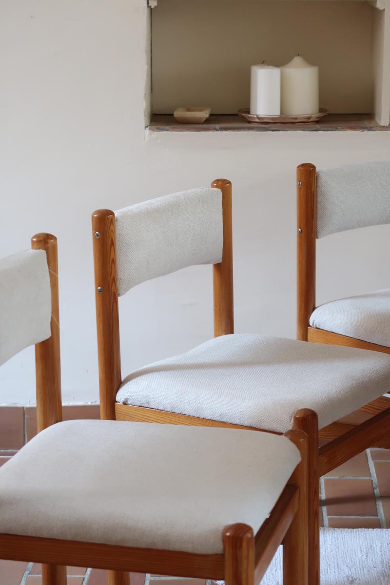 Lot de six chaises vintage des années 80 en pin massif avec assise et dossier en tissu bouclette blanc cassé, style Charlotte Perriand, présentées seules ou mises en situation dans différents espaces.