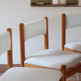 Lot de six chaises vintage des années 80 en pin massif avec assise et dossier en tissu bouclette blanc cassé, style Charlotte Perriand, présentées seules ou mises en situation dans différents espaces.