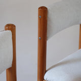 Lot de six chaises vintage des années 80 en pin massif avec assise et dossier en tissu bouclette blanc cassé, style Charlotte Perriand, présentées seules ou mises en situation dans différents espaces.