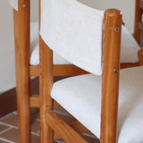 Lot de six chaises vintage des années 80 en pin massif avec assise et dossier en tissu bouclette blanc cassé, style Charlotte Perriand, présentées seules ou mises en situation dans différents espaces.