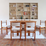 Lot de six chaises vintage des années 80 en pin massif avec assise et dossier en tissu bouclette blanc cassé, style Charlotte Perriand, présentées seules ou mises en situation dans différents espaces.