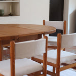 Lot de six chaises vintage des années 80 en pin massif avec assise et dossier en tissu bouclette blanc cassé, style Charlotte Perriand, présentées seules ou mises en situation dans différents espaces.