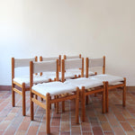 Lot de six chaises vintage des années 80 en pin massif avec assise et dossier en tissu bouclette blanc cassé, style Charlotte Perriand, présentées seules ou mises en situation dans différents espaces.