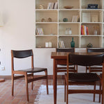 Lot de cinq chaises scandinaves vintage en teck des années 60, style Erik Buch, avec assise et dossier en skaï marron, accompagné d’une sixième chaise offerte présentant une petite déchirure sur le dossier, présentées seules et en mise en situation.