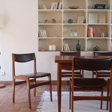 Lot de cinq chaises scandinaves vintage en teck des années 60, style Erik Buch, avec assise et dossier en skaï marron, accompagné d’une sixième chaise offerte présentant une petite déchirure sur le dossier, présentées seules et en mise en situation.