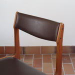 Lot de cinq chaises scandinaves vintage en teck des années 60, style Erik Buch, avec assise et dossier en skaï marron, accompagné d’une sixième chaise offerte présentant une petite déchirure sur le dossier, présentées seules et en mise en situation.