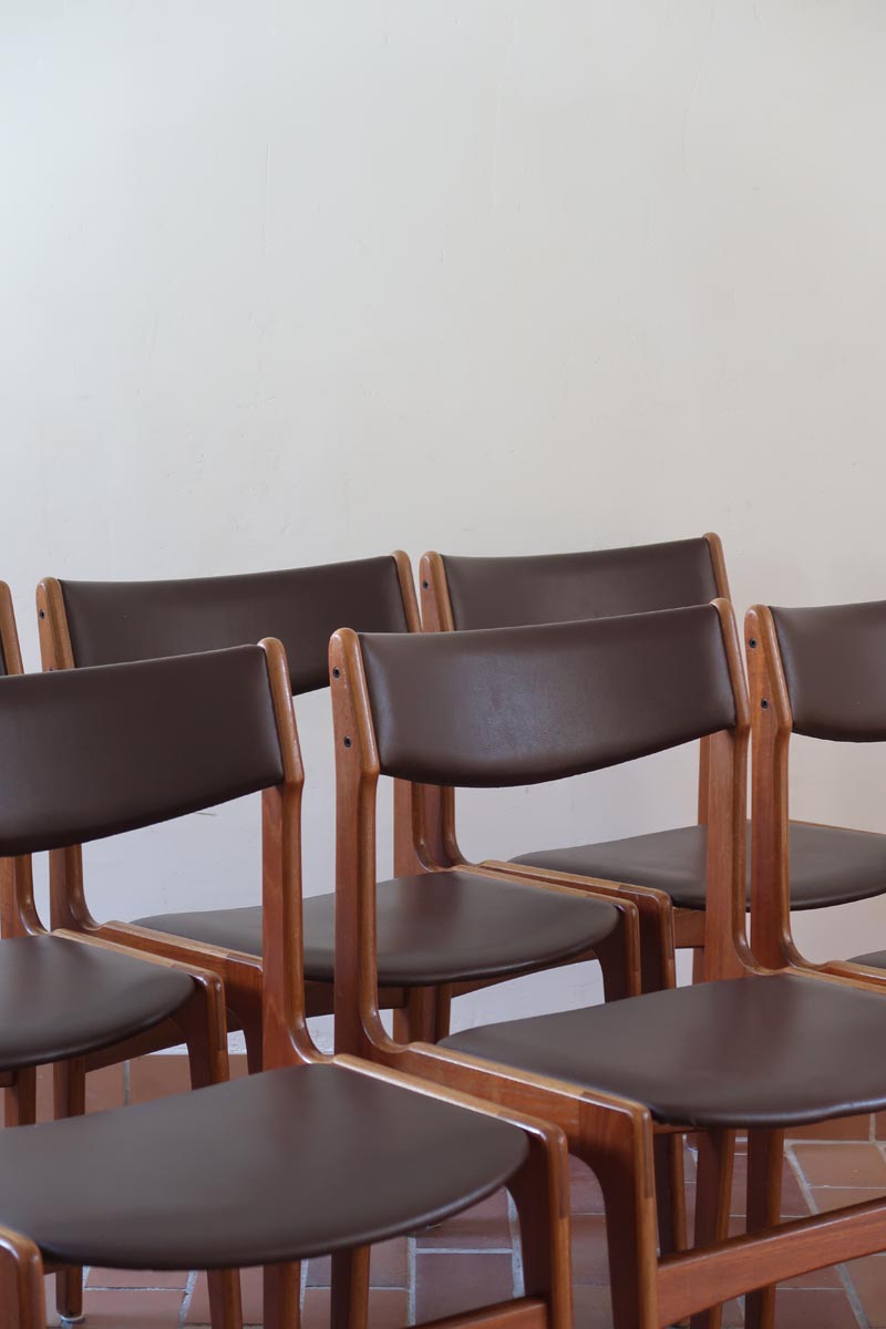 Lot de cinq chaises scandinaves vintage en teck des années 60, style Erik Buch, avec assise et dossier en skaï marron, accompagné d’une sixième chaise offerte présentant une petite déchirure sur le dossier, présentées seules et en mise en situation.