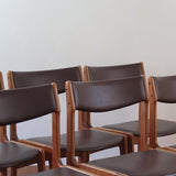 Lot de cinq chaises scandinaves vintage en teck des années 60, style Erik Buch, avec assise et dossier en skaï marron, accompagné d’une sixième chaise offerte présentant une petite déchirure sur le dossier, présentées seules et en mise en situation.