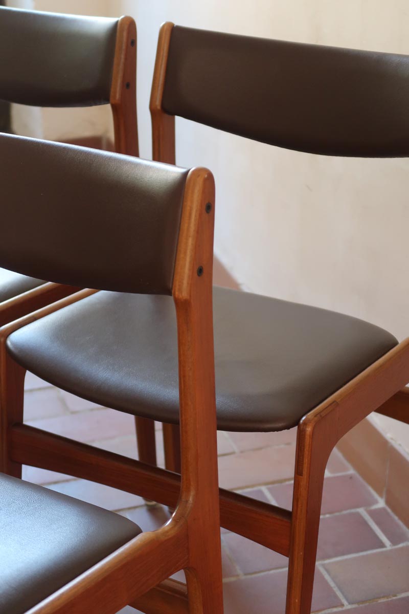 Lot de cinq chaises scandinaves vintage en teck des années 60, style Erik Buch, avec assise et dossier en skaï marron, accompagné d’une sixième chaise offerte présentant une petite déchirure sur le dossier, présentées seules et en mise en situation.